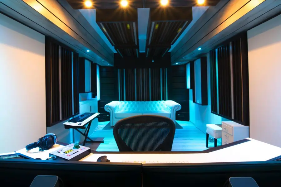 Die Regie der OYES Studios mit Chesterfield-Sofa, Akustikelementen und warmem Licht